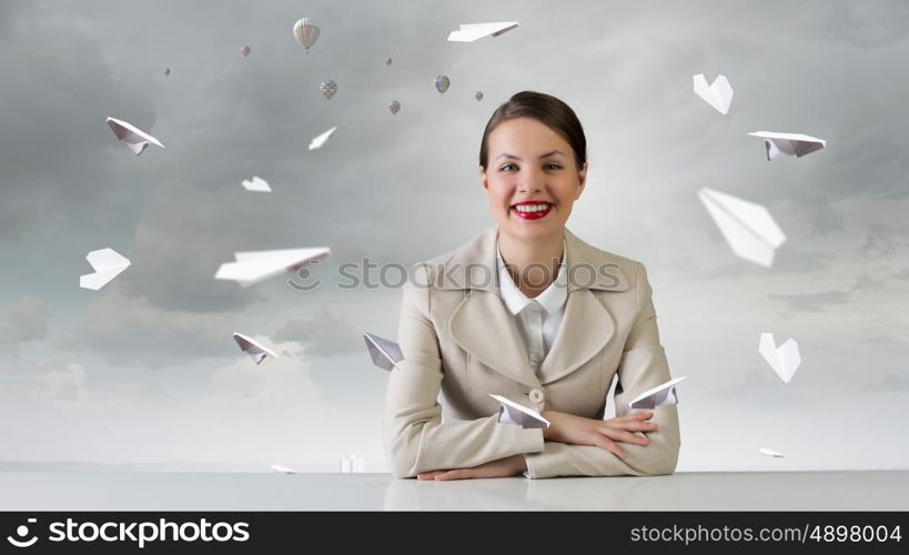 Businesswoman sitting at desk. Happy attractive businesswoman sitting at table in office