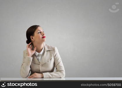 Businesswoman sitting at desk. Happy attractive businesswoman sitting at table in office