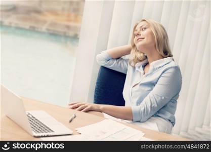 Businesswoman sitting at desk relaxed in offfice