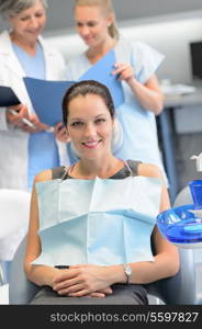 Businesswoman sitting chair dental surgery dentist checkup assistant in background