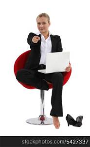 Businesswoman sitting in a chair and pointing her index finger