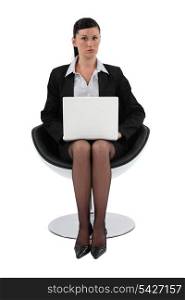 Businesswoman sitting in a modern chair and using her laptop