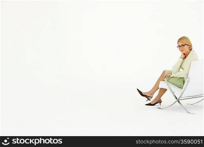 Businesswoman sitting in chair on white background portrait