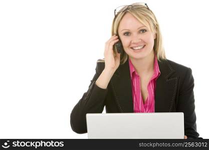Businesswoman Sitting In Front Of Laptop Talking On Mobile Phone