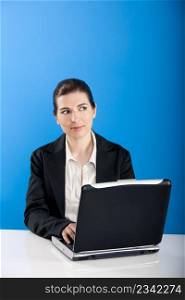 Businesswoman sitting in office with a laptop