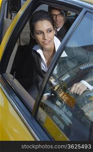 Businesswoman sitting in taxi and looking out window