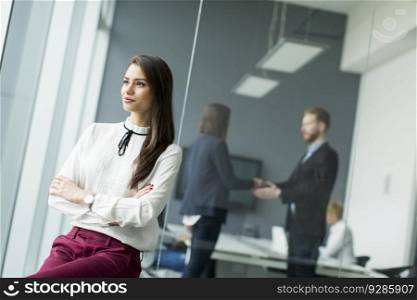 Businesswoman sitting in the office with her arms crossed