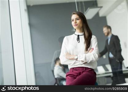 Businesswoman sitting in the office with her arms crossed