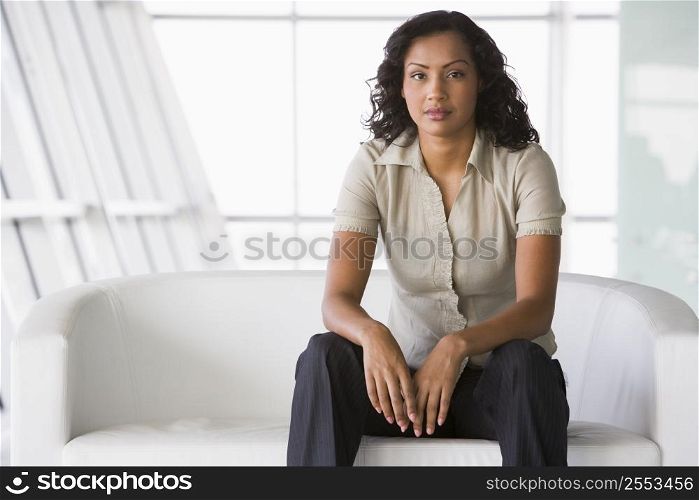 Businesswoman sitting indoors (high key/selective focus)