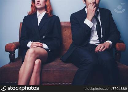 Businesswoman sitting next to nervous businessman