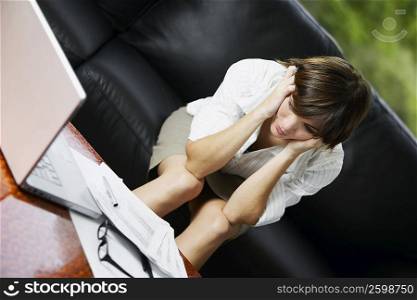 Businesswoman sitting on a couch and looking worried