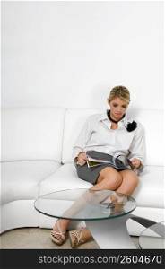 Businesswoman sitting on a couch and reading a magazine