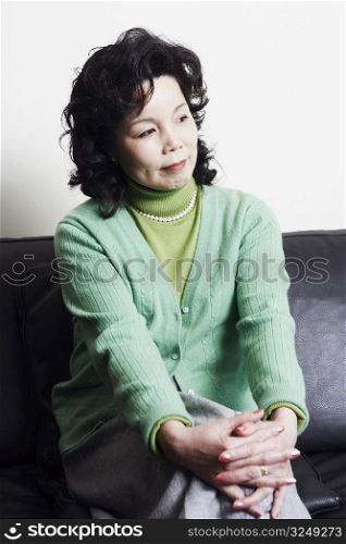 Businesswoman sitting on a couch thinking