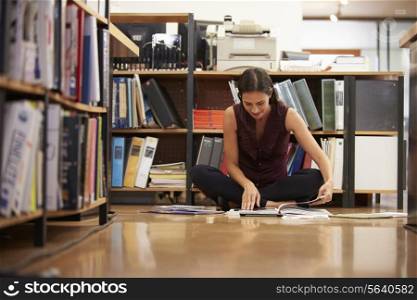 Businesswoman Sitting On Office Floor Reading Documents