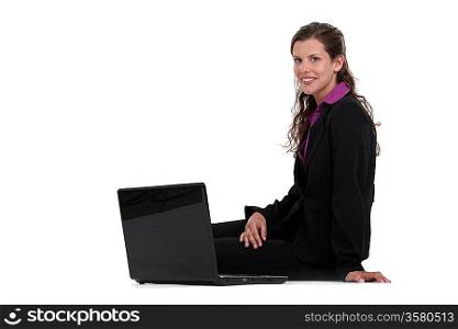 Businesswoman sitting on the floor with her laptop