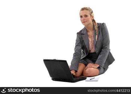 Businesswoman sitting on the floor with laptop