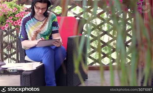 Businesswoman sitting outside and working with a tablet pc and papers