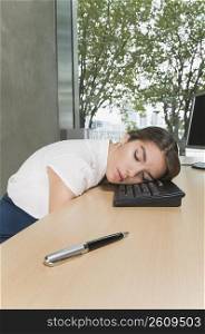 Businesswoman sleeping on a desk in an office