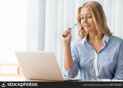 Businesswoman smiling and sitting in offfice