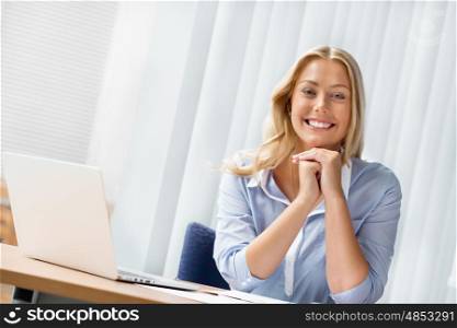 Businesswoman smiling and sitting in offfice