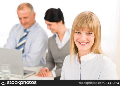 Businesswoman smiling at team meeting with colleagues