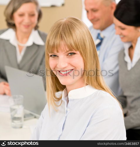 Businesswoman smiling at team meeting with colleagues