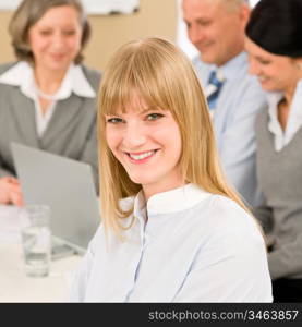 Businesswoman smiling at team meeting with colleagues