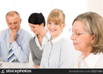 Businesswoman smiling at team meeting with colleagues