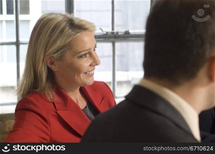 Businesswoman smiling with a businessman beside her