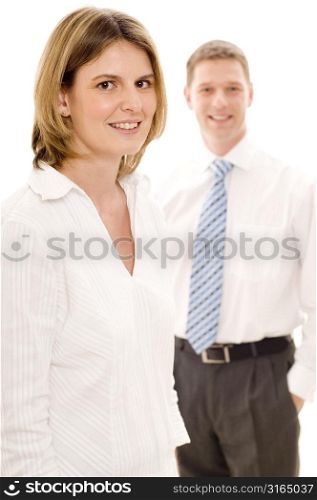 Businesswoman smiling with a businessman standing behind her