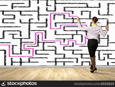 Businesswoman solving maze problem. Back view image of young businesswoman trying to find way in labyrinth