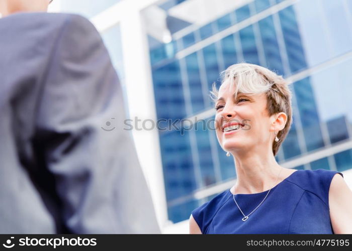 Businesswoman standing and talking to her colleague outdoors. Nice talk out of the office