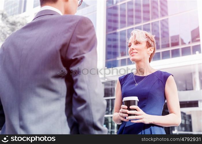 Businesswoman standing and talking to her colleague outdoors. Nice talk out of the office
