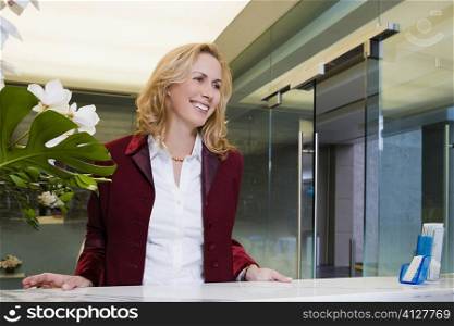 Businesswoman standing at the hotel reception and smiling