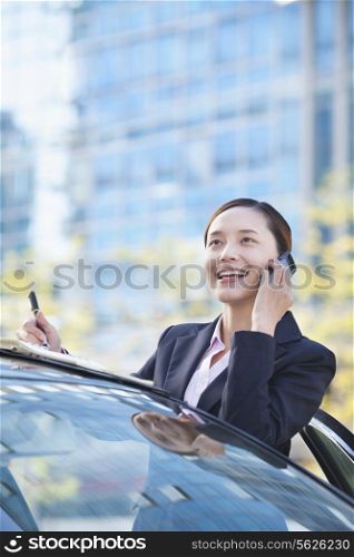 Businesswoman Standing by Car Using Phone