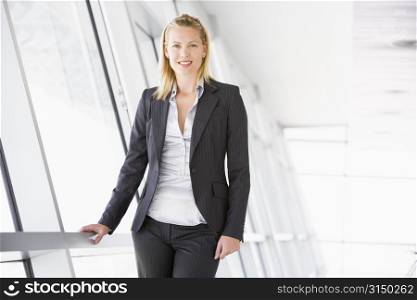 Businesswoman standing in corridor smiling