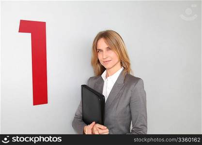 Businesswoman standing in hall against wall