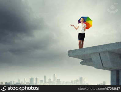 Businesswoman standing on bridge. Young businesswoman with umbrella standing on bridge