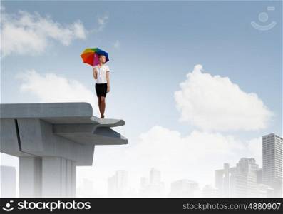 Businesswoman standing on bridge. Young businesswoman with umbrella standing on bridge