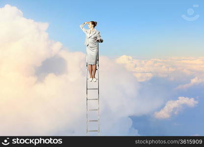 Businesswoman standing on ladder looking into distance against cloudy background