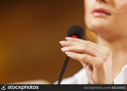 Businesswoman standing on stage and reporting for audience. Speaker at stage