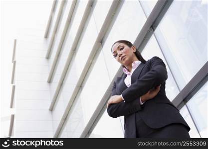 Businesswoman standing outdoors by building (high key/selective focus)