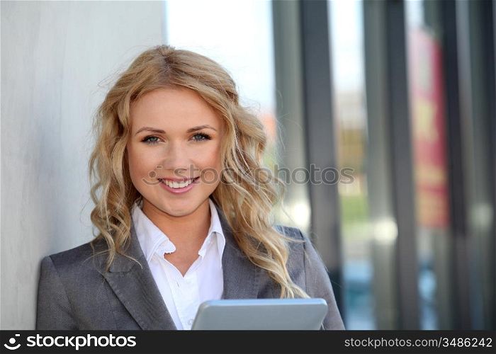 Businesswoman standing outside with electronic tablet