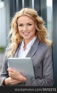 Businesswoman standing outside with electronic tablet