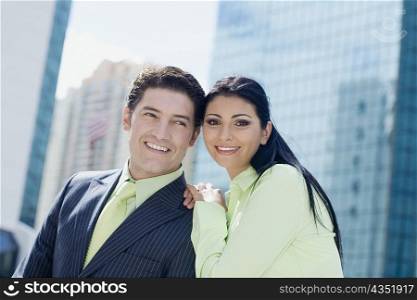 Businesswoman standing with a businessman and smiling