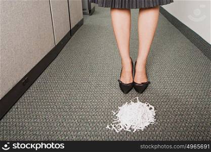 Businesswoman stood in front of pile of paper shreddings