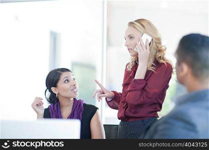 Businesswoman taking call by colleague