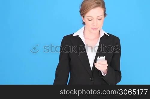 Businesswoman Talking Into Mobile Phone, upper body isolated on blue with copyspace.