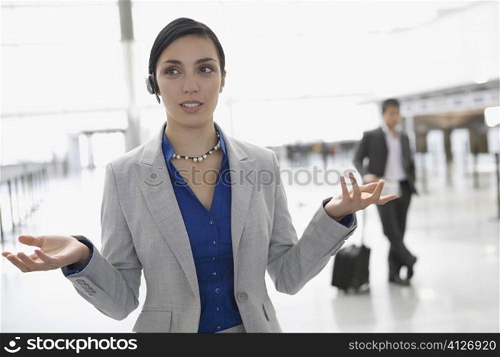 Businesswoman talking on a hands free device at an airport lounge