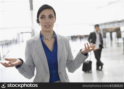 Businesswoman talking on a hands free device at an airport lounge